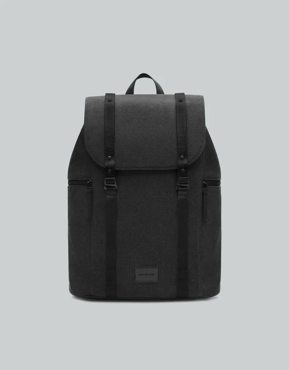 プレーンな背景に置かれた、GASTON LUGAのロゴが入ったダークグレーのバックパックです。