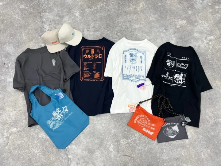 博多グルメや食品をモチーフにしたTシャツ、キャップ、エコバッグ、ポーチなどのアパレル・雑貨コレクション