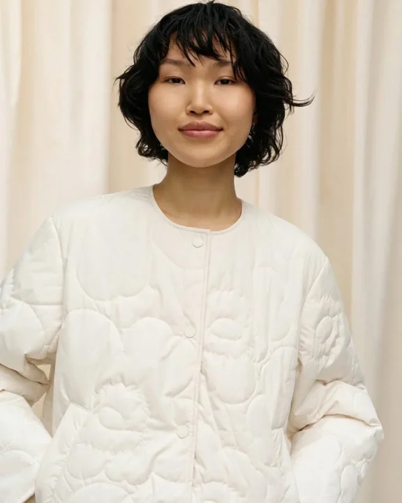 白いキルティングジャケットを着用した女性