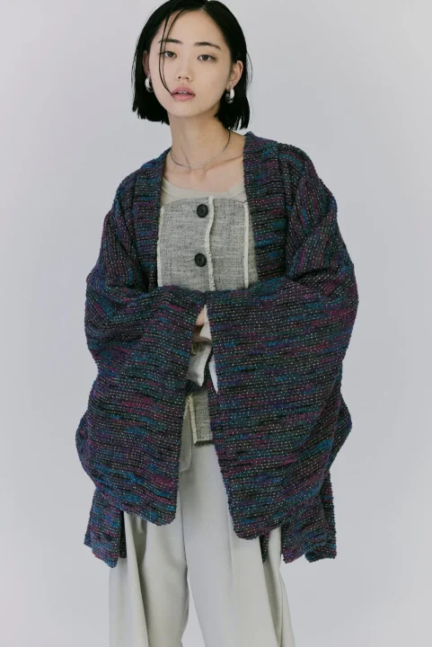 カラフルなツイード風のジャケットとワイドパンツを着用した女性