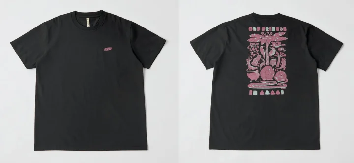 黒いTシャツの前面には「KEEN」のロゴ、背面には「OLD FRIENDS」の文字と、カエルやヘビ、鳥などの動物と植物が描かれたピンクと水色の複雑なグラフィックデザインが特徴です。