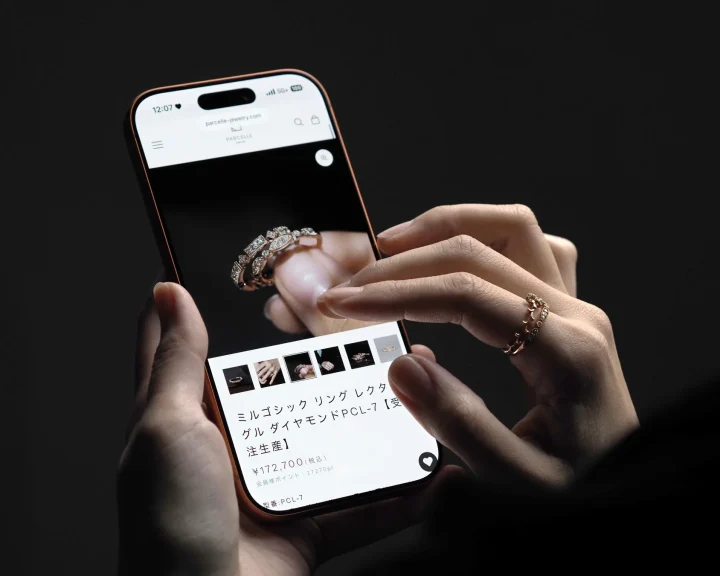 スマートフォンでダイヤモンドリングのオンラインストアを閲覧している手元