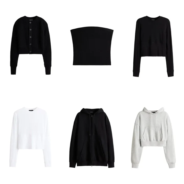 白い背景に、黒のカーディガン、チューブトップ、長袖Tシャツ、白の長袖Tシャツ、黒のジップアップパーカー、グレーのクロップドパーカーなど、様々なトップスが展示されています。主に黒、白、グレーのシンプルなカジュアルウェアが特徴です。