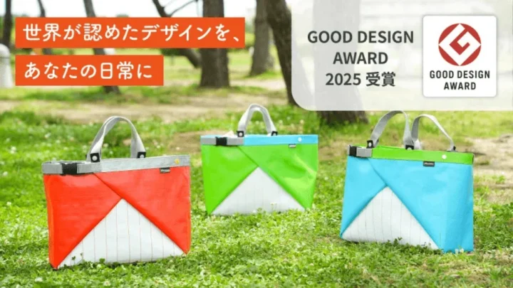 グッドデザイン賞2025を受賞した、赤、緑、青のカラフルなデザインバッグが芝生の上に並べられている