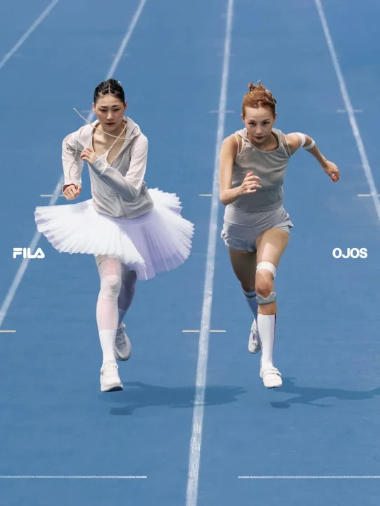 陸上トラックを走るバレエチュチュとスポーツウェアの女性