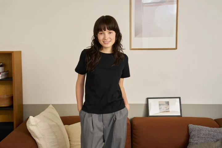 黒いTシャツとグレーのパンツを着用した若い女性