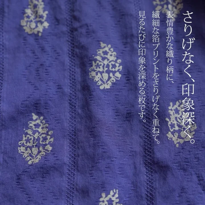 紫色の布地に織り柄と箔プリントが施されたテキスタイル