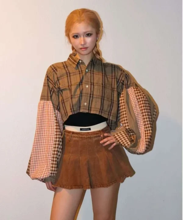 クロップドシャツとプリーツスカートの女性