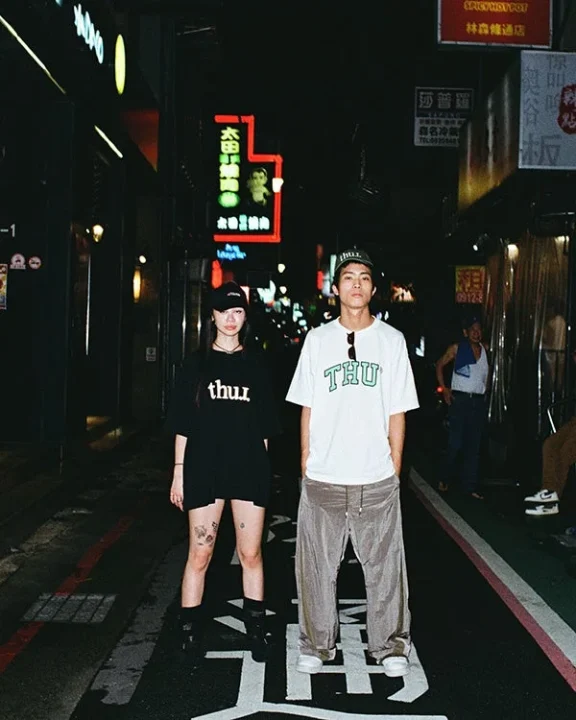 夜のアジアの街角でポーズをとる男女