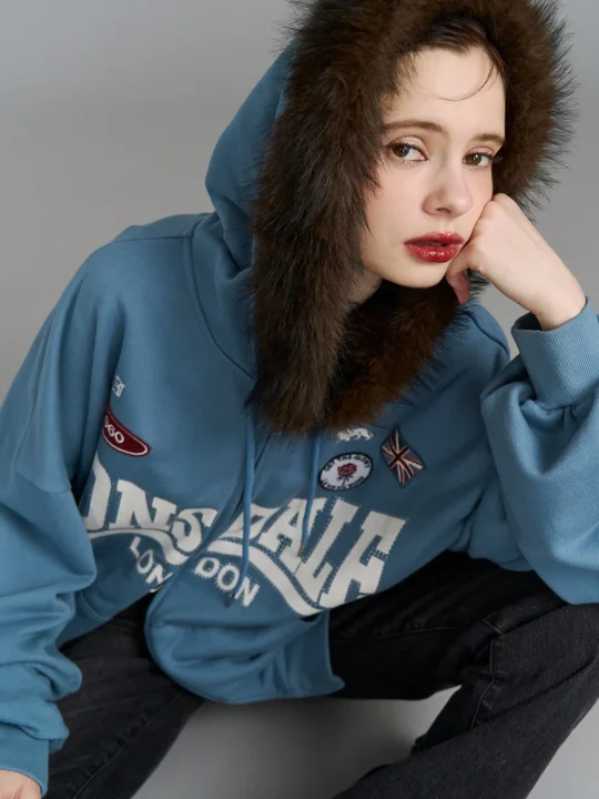 ファー付きフードの青いパーカーを着用した女性が座っているポートレート