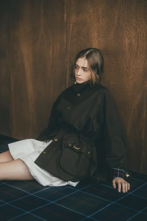 Barbourジャケットと白スカートを着用した女性