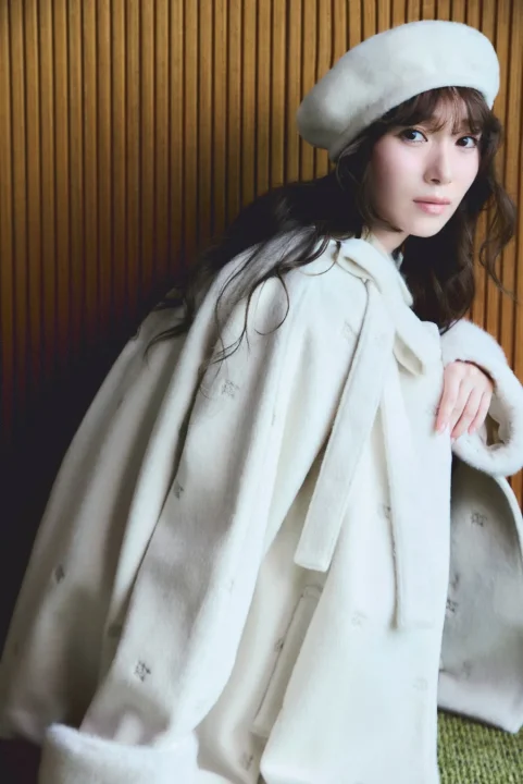白いファー付きコートとベレー帽を着用した女性