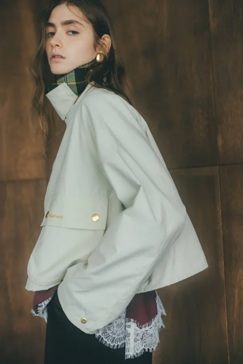 白いバブアーのジャケットを着た若い女性
