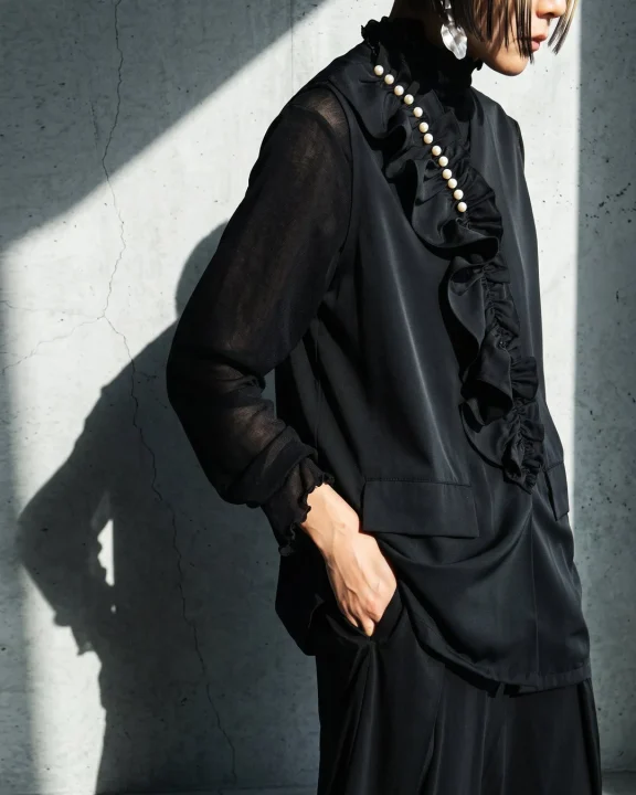 黒いラッフルブラウスのファッション