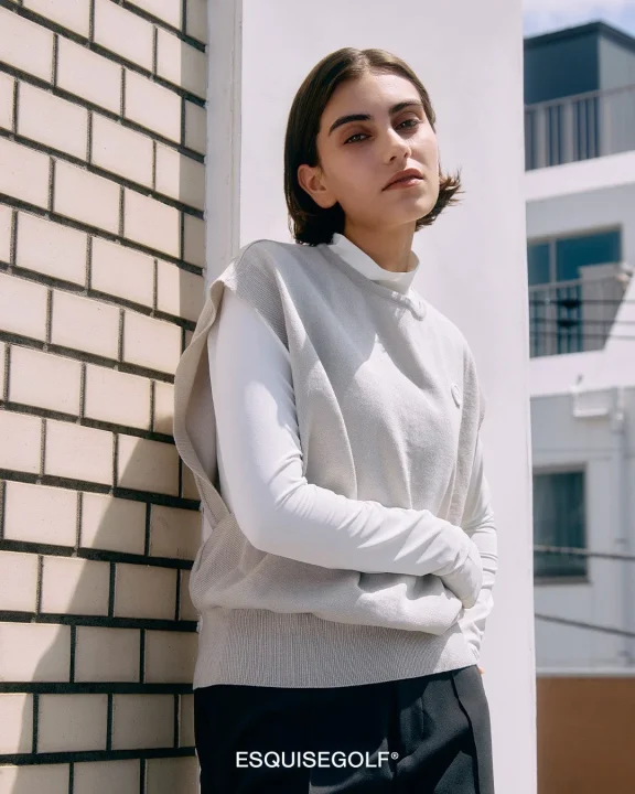 ベージュのニットベストを着用した女性モデル