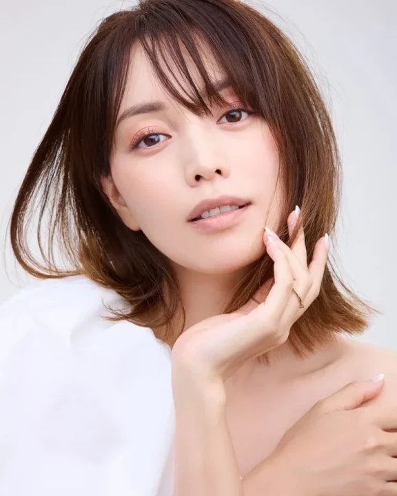茶色のショートヘアの女性が優しい表情でカメラを見つめているクローズアップポートレート。
