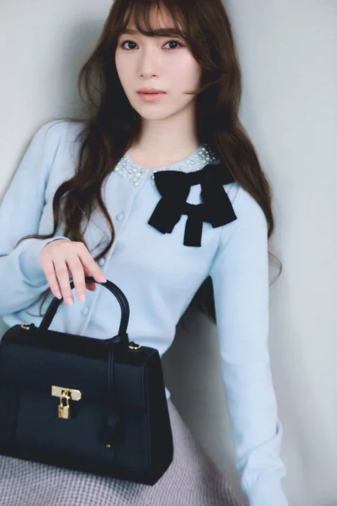 水色のカーディガンを着用した女性