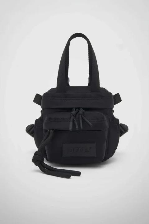 白い背景に置かれた黒いミニトートバッグ。複数のポケットとドローストリングのディテールがあり、前面には「DONE!」のロゴが確認できます。
