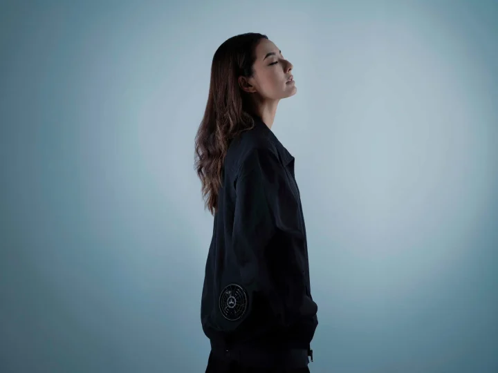 ファン付きジャケットを着用し目を閉じる女性の横顔