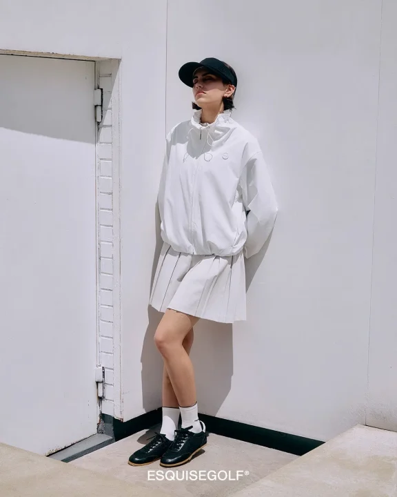 白いゴルフウェアを着用した女性モデル