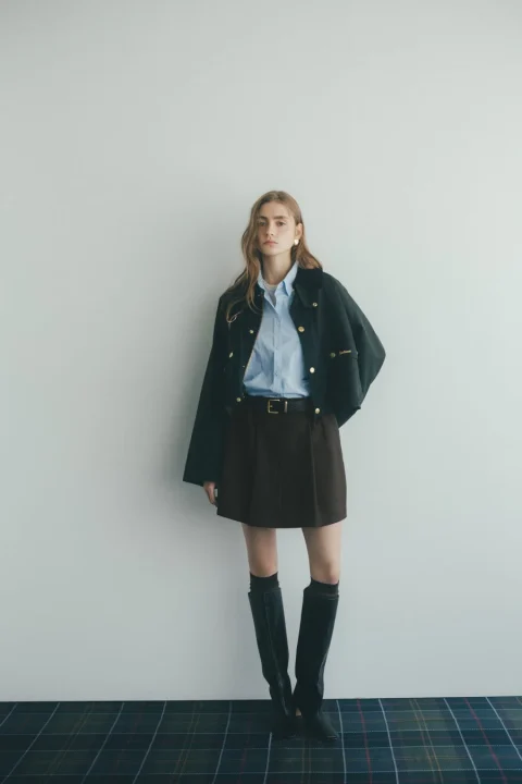 ライトブルーシャツに黒のショート丈ジャケットを合わせた女性